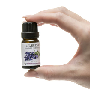 A hand holds a small brown bottle from the Rio Aromatherapy 100% Essential Oil Collection, labeled Lavender and featuring lavender sprigs, showcasing one of the finest aromatherapy oils against a white background.