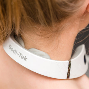 A close-up of a person wearing the Neck & Shoulder Massager around their neck, with electrodes making contact with the skin to provide electrical muscle stimulation.