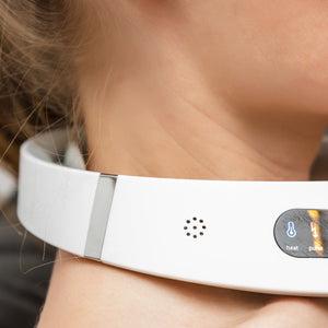 A close-up of a person wearing the Neck & Shoulder Massager, featuring a display screen with buttons for heat and pulse functions, resting comfortably around the back of the neck.