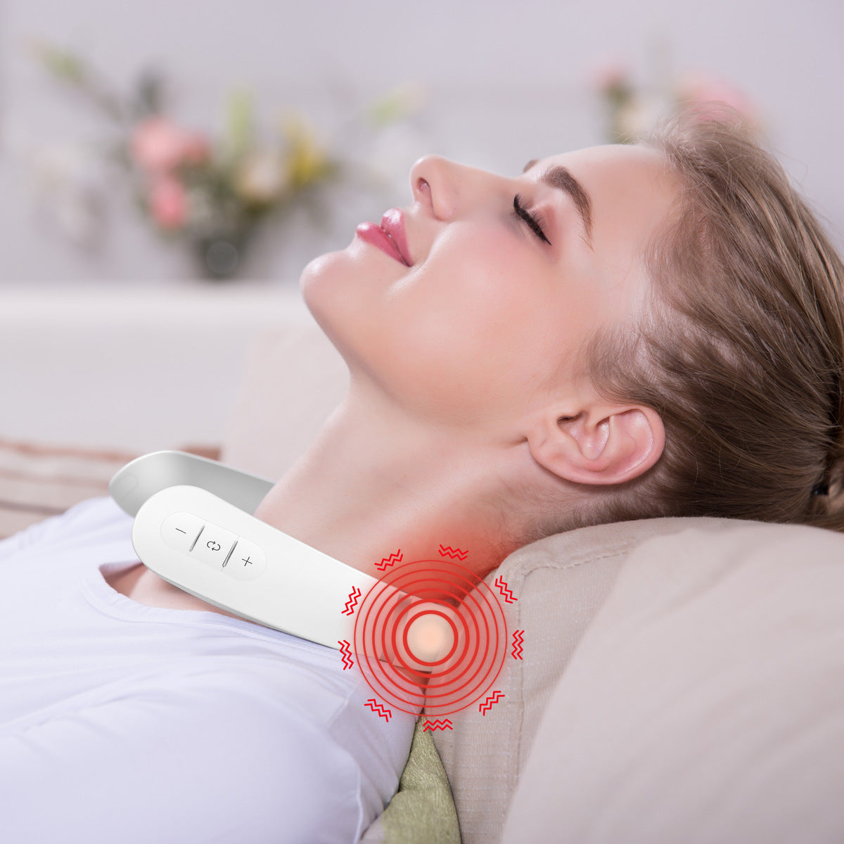 A woman relaxes on a couch using the Neck & Shoulder Massager, its buttons visible as soothing heat is highlighted by a red glow, providing ultimate relaxation.