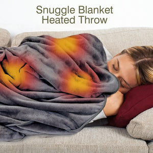 A woman relaxes on a couch with a Cozy Wireless Rechargeable Snuggle Blanket Heated Throw in warm yellow and red tones. "Snuggle Blanket Heated Throw" is displayed above her.
