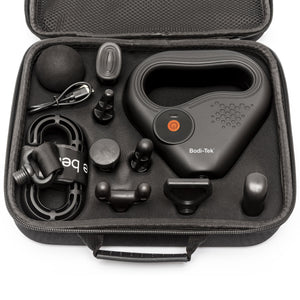 A black carrying case holds the SPORTS PERCUSSION MASSAGE GUN WITH LATERAL ACTION BELT, multiple massage heads, a black massage ball, charging cable, and a strap—all organized in foam slots for muscle recovery.