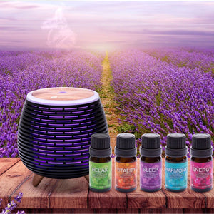 A black diffuser on a wooden table emits mist at sunset, with the Rio Wellbeing Collection Aromatherapy Essential Oils—Relax, Vitality, Sleep, Harmony, and Energy—in front. A lavender field forms the serene backdrop.