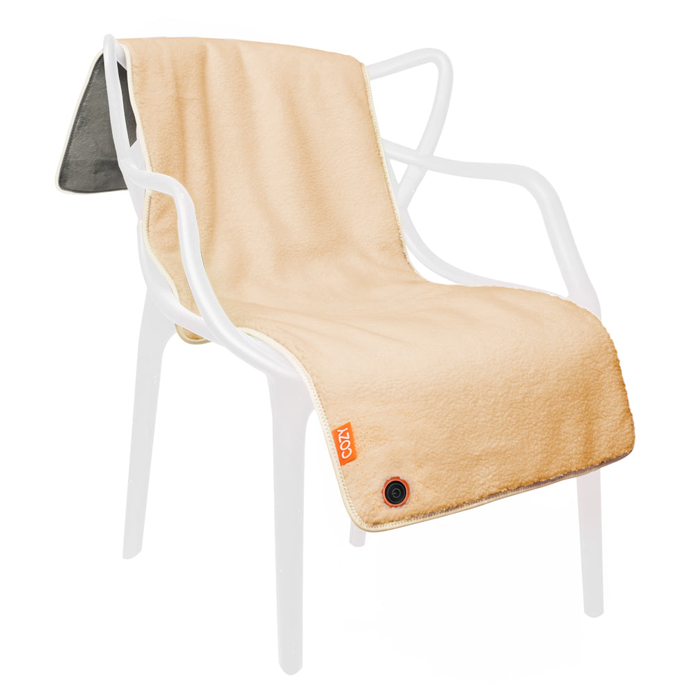 A COZY Heated Throw & Seat Cover Pad - JORV in beige, featuring a small power button and label in one corner, is draped over a modern white plastic chair; its underside is made of darker gray material.