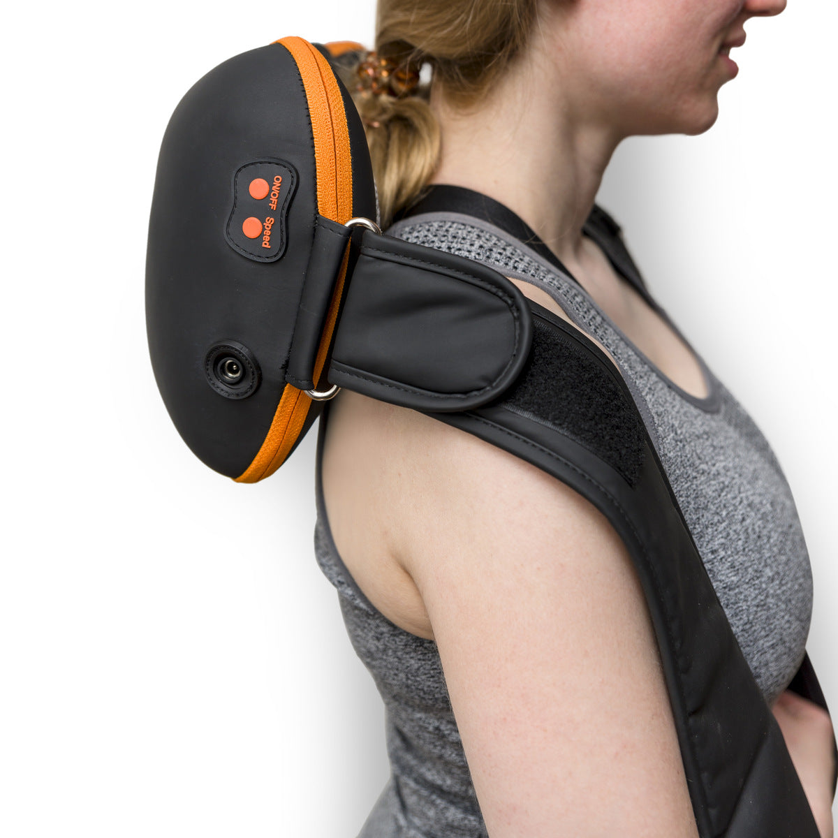 A woman in a gray tank top uses the Neck, Shoulder & Body Shiatsu Massager, a black and orange device with visible control buttons, draped over her neck and shoulders.