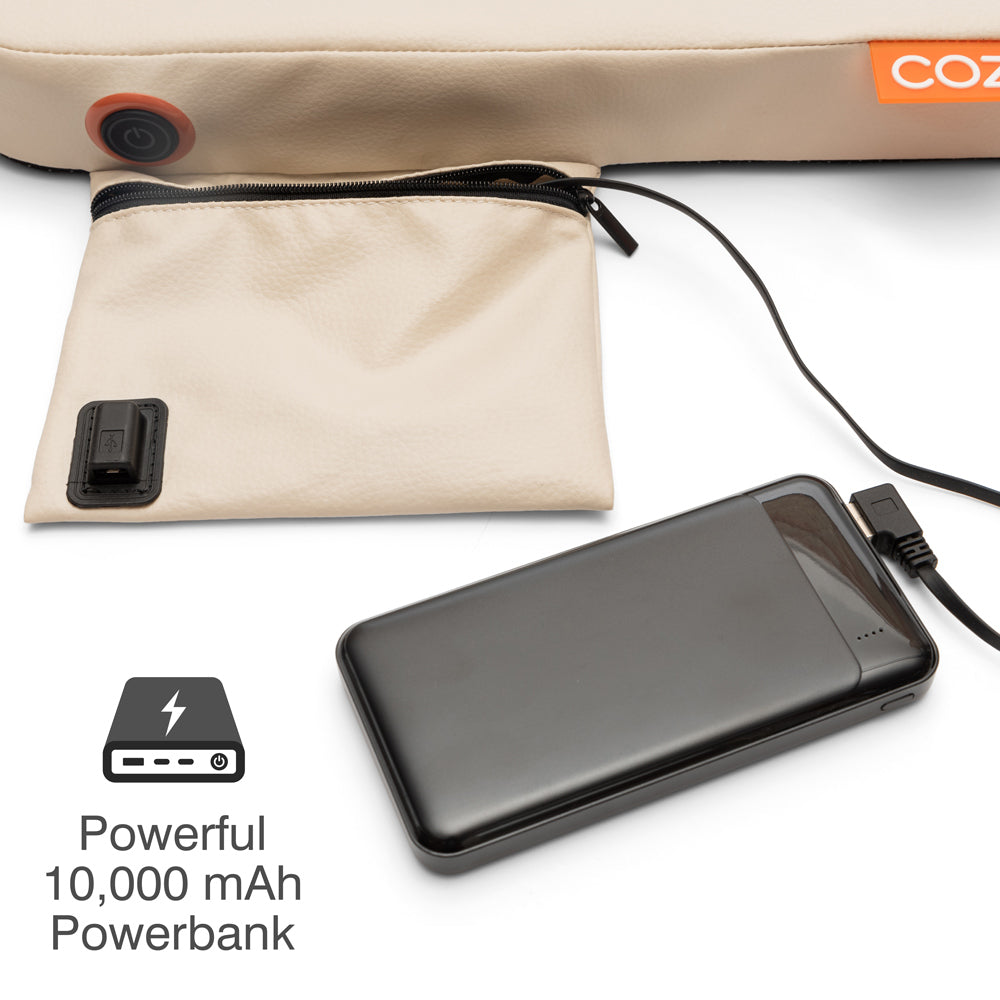 A black 10,000 mAh power bank connects to the COZY Cordless Heated Seat Pad - JORD, shown beside a beige zippered pouch attached to a larger beige item. Text below reads Powerful 10,000 mAh Powerbank with a battery icon.