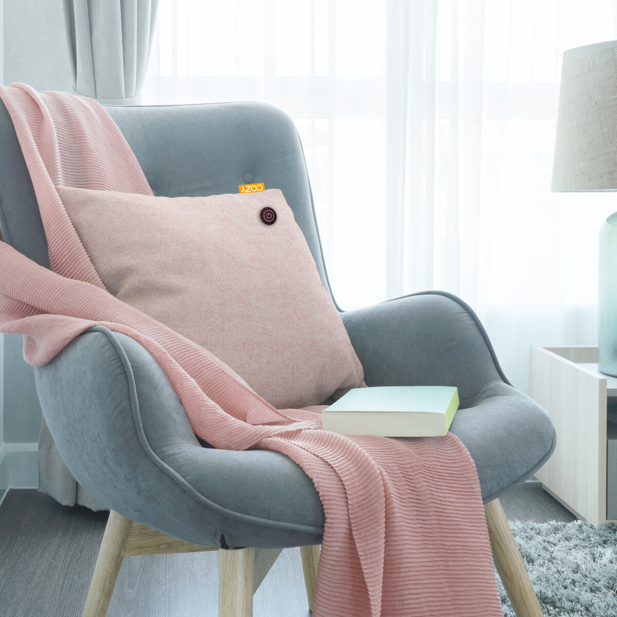 Pink cushion shown in a blue padded arm chair.