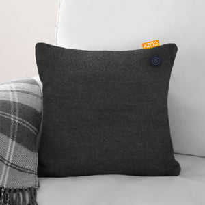 Black heated cushion shown in a grey sofa with black and white blanket.