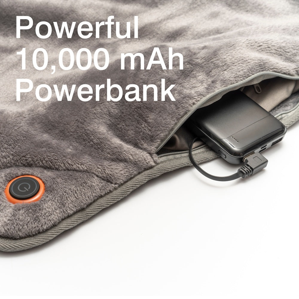 A close-up of the Cozy Wireless Rechargeable Snuggle Blanket Heated Throw in gray shows its soft fabric, a pocket holding a connected black 10,000 mAh power bank, and a round power button. Text reads: Powerful 10,000 mAh Powerbank.