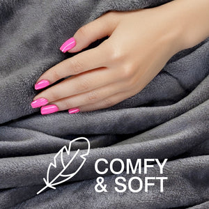 A hand with bright pink nails rests on a plush gray Cozy Wireless Rechargeable Snuggle Blanket Heated Throw. At the bottom, a feather illustration and “COMFY & SOFT” in white text highlight its comfort.