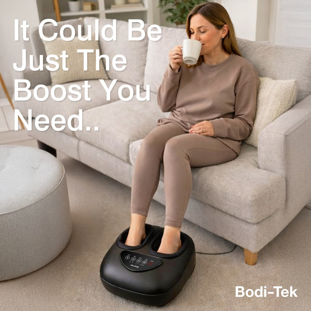 A woman relaxes on a sofa, sipping from a white mug with her feet in the black Foot-Therapy 3 in 1 Massager. Text on the image reads, "It Could Be Just The Boost You Need.." and "Bodi-Tek.