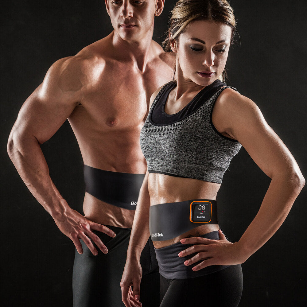 A fit man and woman in athletic wear showcase their toned abs while wearing sleek black Ab & Back Muscle Strengthener with heat belts. The woman pairs hers with a gray sports bra against a dark background.