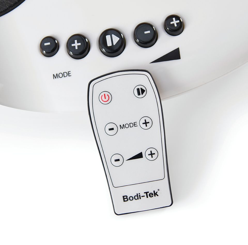A close-up of the Circulation Plus Active Lower Leg & Foot Exerciser (2025) remote and device panel, featuring power, mode, play/pause, and volume buttons. The white remote displays black symbols and text for easy control.