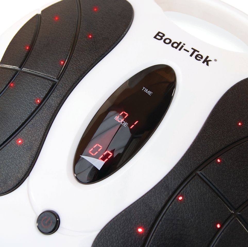 Close-up of the Circulation Plus Active Lower Leg & Foot Exerciser (2025), an electronic massager with a digital display showing 01 for time and mode, red indicator lights, a circular power button, and a black-and-white design.