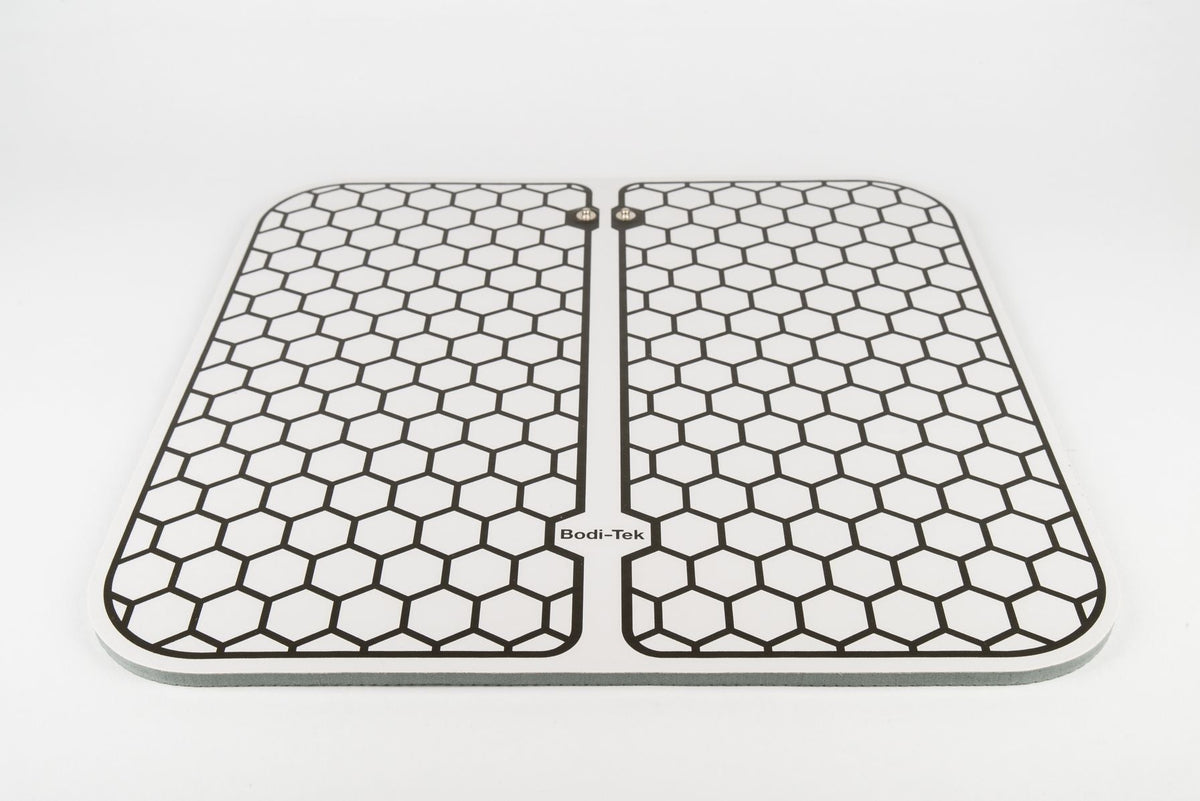 The Circulation Plus Boost & Revive Mat, a rectangular muscle stimulator with a honeycomb pattern and Bodi-Tek branding at the bottom center, is placed on a white background.