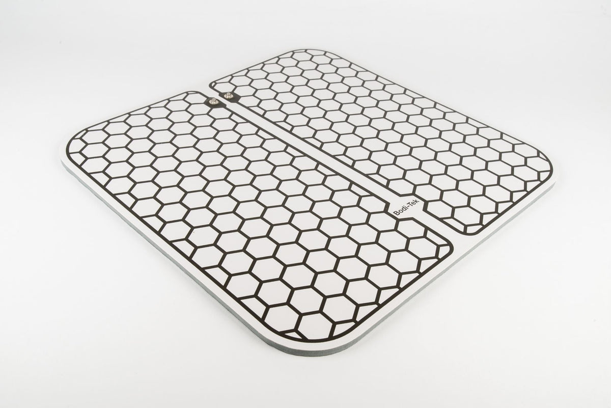 A pair of Circulation Plus Boost & Revive Mat pads with rounded corners and a black hexagonal grid on a white background—perfect for muscle stimulators—are shown side by side on a plain white surface.