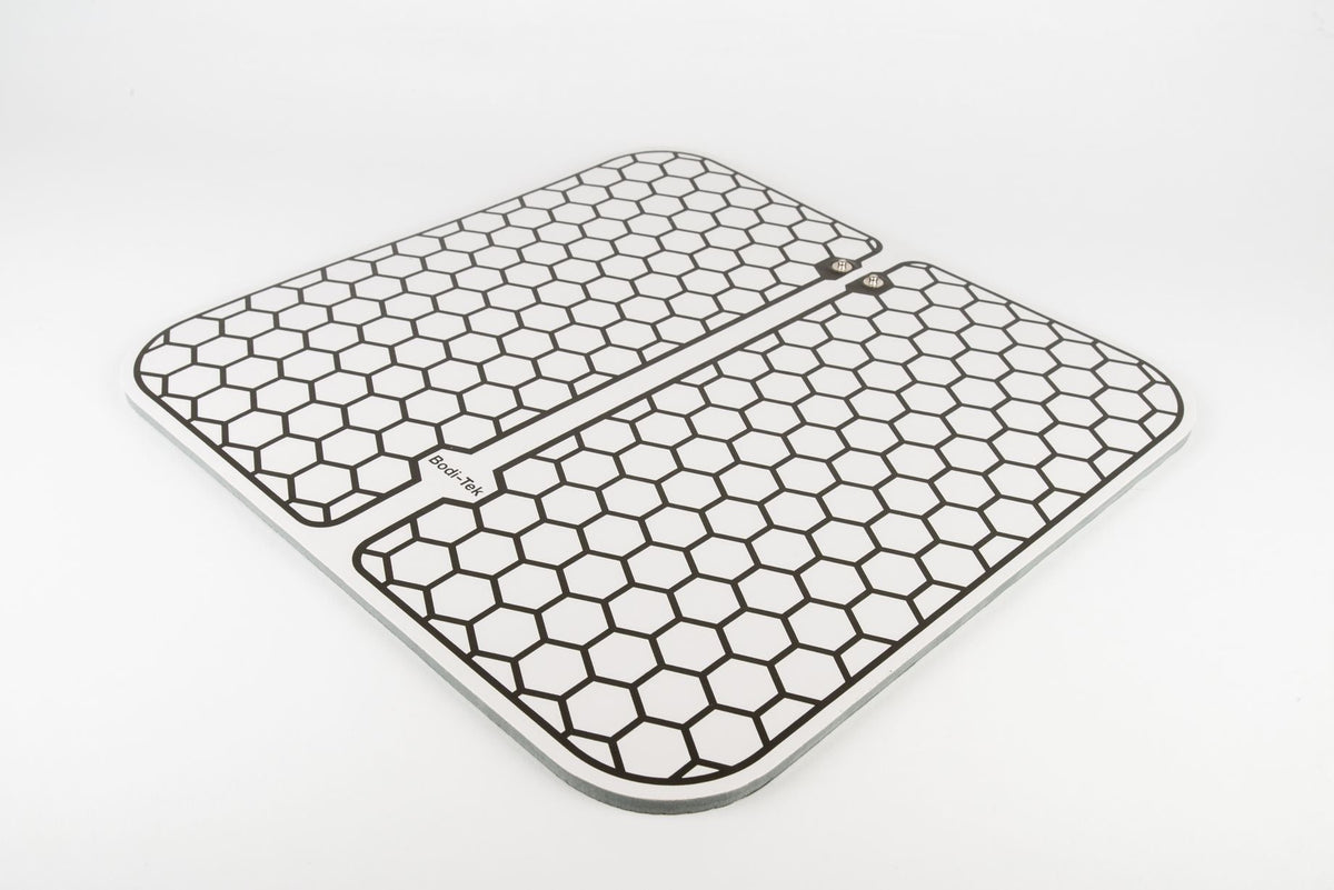 Two Circulation Plus Boost & Revive Mats, rectangular and white with black hexagonal honeycomb patterns and rounded corners, are placed side by side on a white background. One mat displays a small label with text.